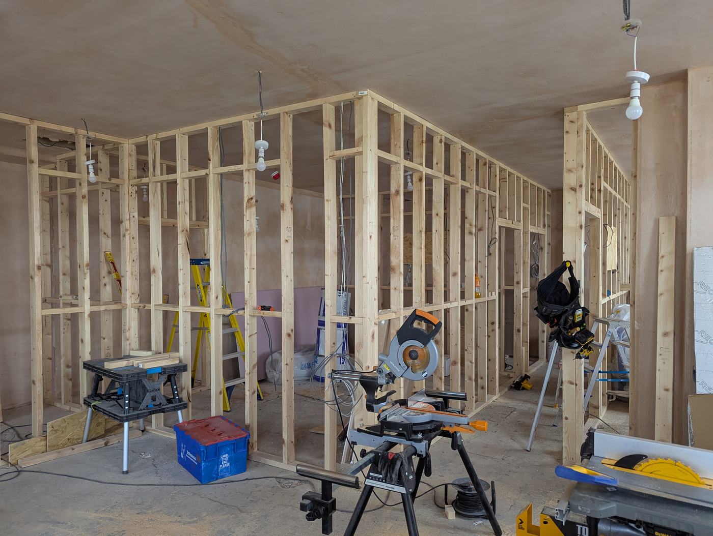 A room mid-build, timber stud walls framed out and ready for insulation and drywall